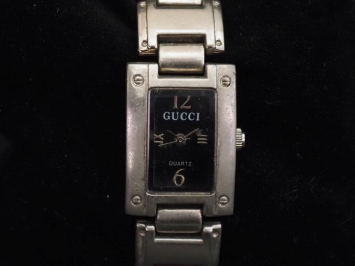 GUCCI,  Montre bracelet de dame en acier.  Cadran rectangulaire à fond
