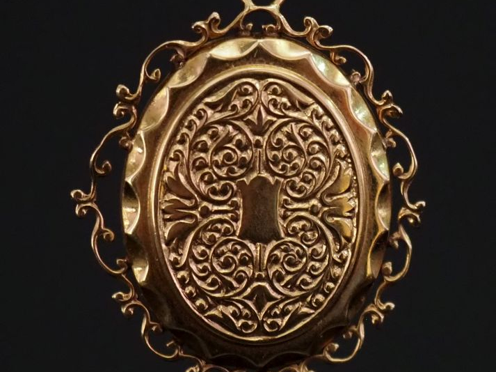 Pendentif ovale en or jaune 750, à décor de rinceaux feuillagés.  Joli