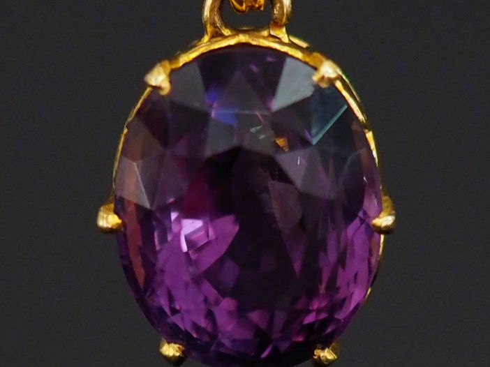 Pendentif en or jaune 750, sertie de verroterie mauve.  Jolie monture 
