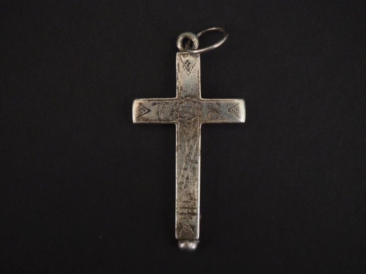 Croix de berceau en argent, à décor gravé.  6 x 3,2 cm Poids. 20,19 g 