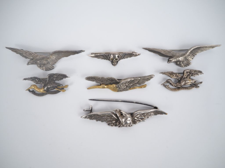 7 différentes broches en argent, métal argenté et doré à décor d'aigle