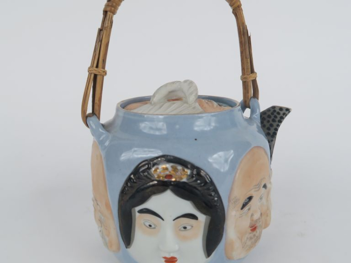 Théière 1900 en porcelaine à décor en relief de têtes de japonais, ans