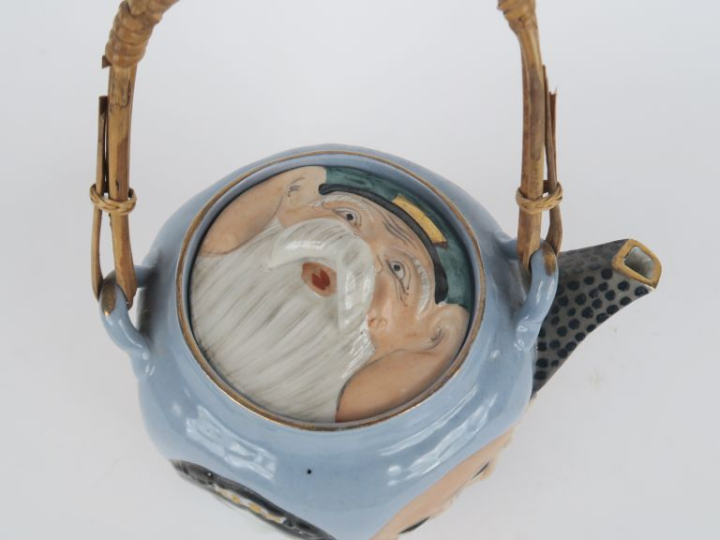Théière 1900 en porcelaine à décor en relief de têtes de japonais, ans
