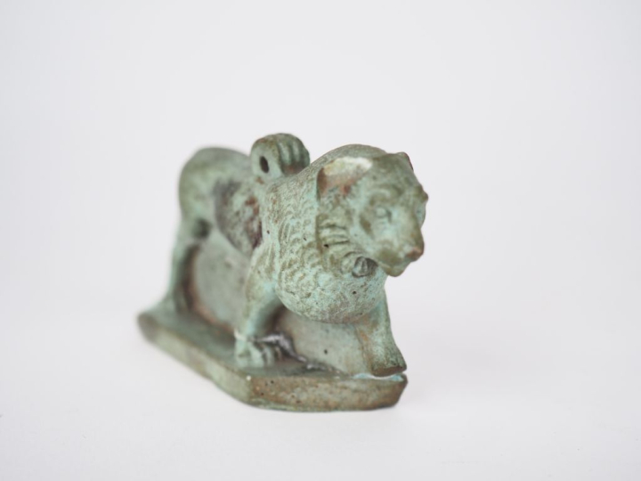 Amulette en faïence egyptienne fiugrant un lion marchant. Basse époque