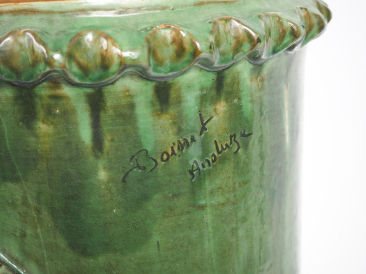 ANDUZE. Porte-parapluies en terre vernissée verte à décor de personnag