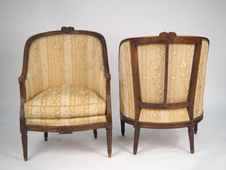 Paire de fauteuils corbeille Louis XVI en noyer mouluré et sculpté, à 