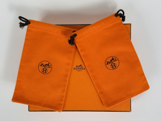 Vente aux enchères HERMES, Paris Boite cartonnée et deux petites pochettes en tissu orang
