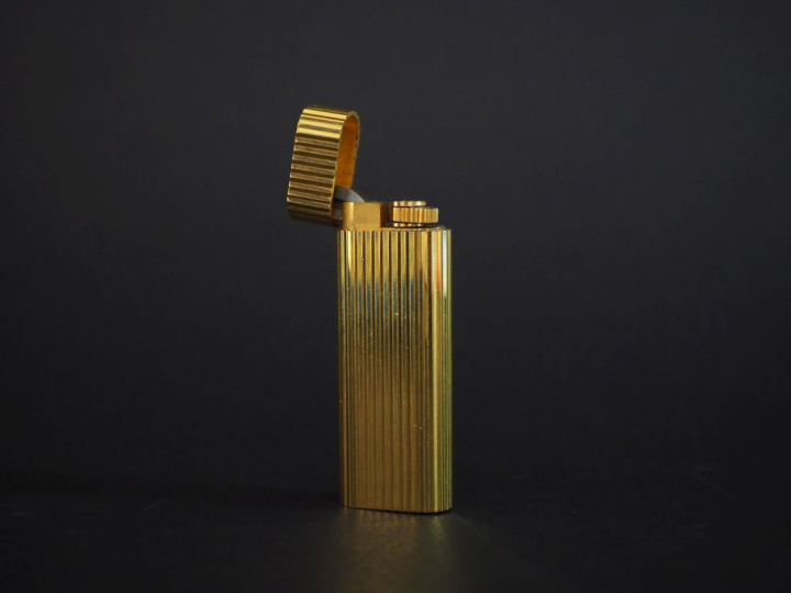 CARTIER, Paris Briquet de poche en plaqué or, à décor de cannelures.  