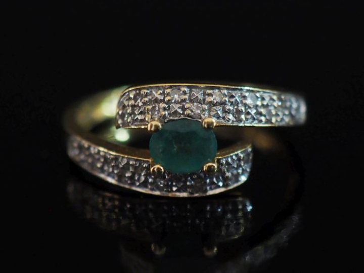 Bague de forme stylisée en or jaune 750, sertie en son centre d'une ém