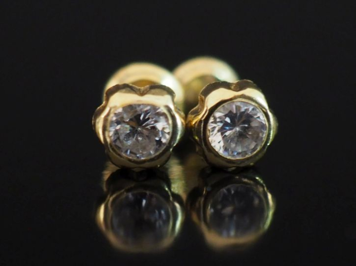 Paire de clous d'oreilles en or jaune 750, sertis d'une pierre à l'imi