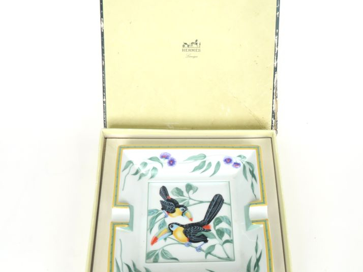 HERMES.  Cendrier en porcelaine polychrome à décor de toucans. Dim. 15