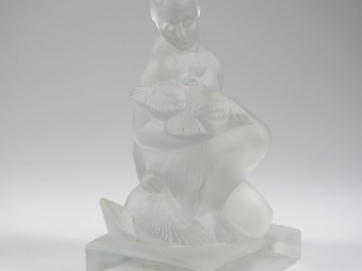 Vente aux enchères Groupe en verre ou cristal moulé "jeune femme aux colombes".  H. 16 cm