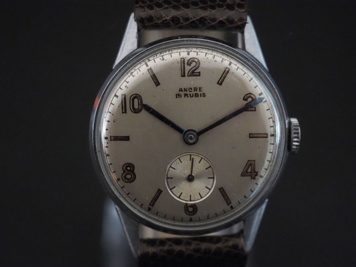 Montre bracelet Swiss made en acier.  Cadran rond à chiffres arabes po