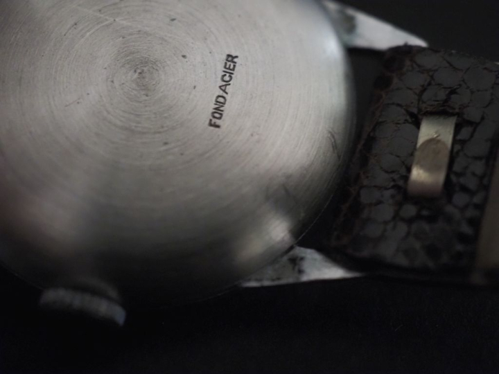 Montre bracelet Swiss made en acier.  Cadran rond à chiffres arabes po