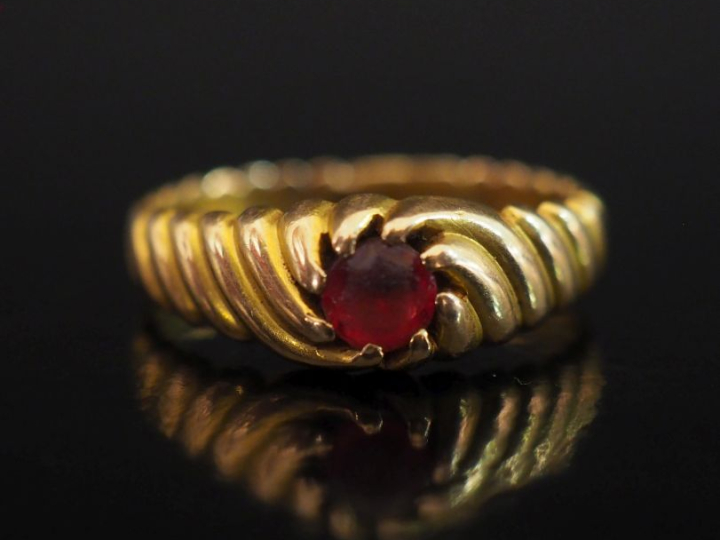 Bague en or jaune 750, à décor de côtes torses et sertie d'une pierre 