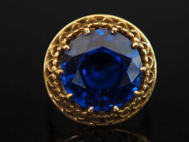 Bague ronde en or jaune 750, sertie en son centre d'un saphir synthéti