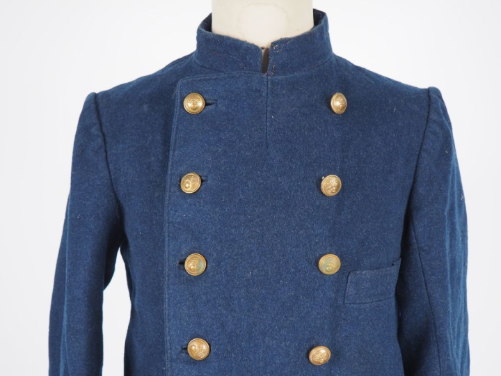 Capote.  En drap gris de fer bleuté.  A double boutonnage de six bouto