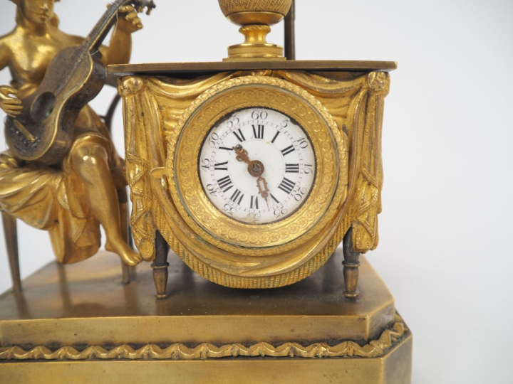 Pendulette musicale de style Directoire en bronze doré, à décor de jeu