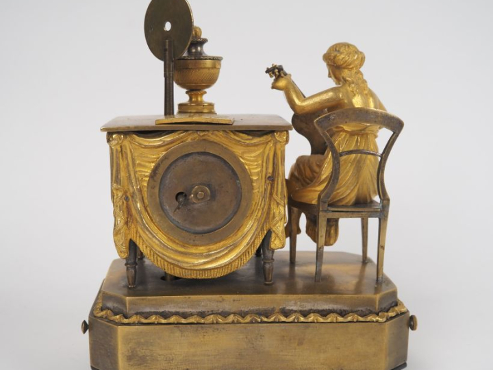 Pendulette musicale de style Directoire en bronze doré, à décor de jeu