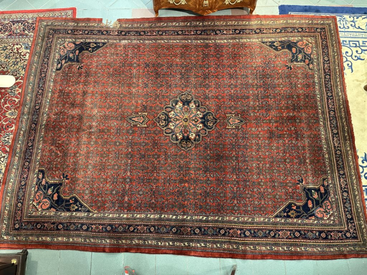 Grand tapis d'Orient à fond rouge. Dim. 2,75 x 3,63 cm. (accident)
