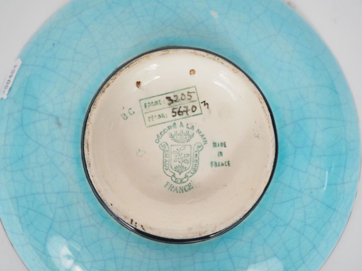LONGWY. Coupe sur talon en porcelaine et émaux polychromes, à décor de