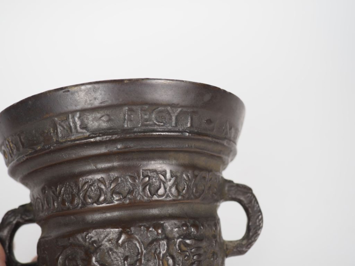 Mortier et son pilon en bronze, à décor d'inscriptions et personnages 