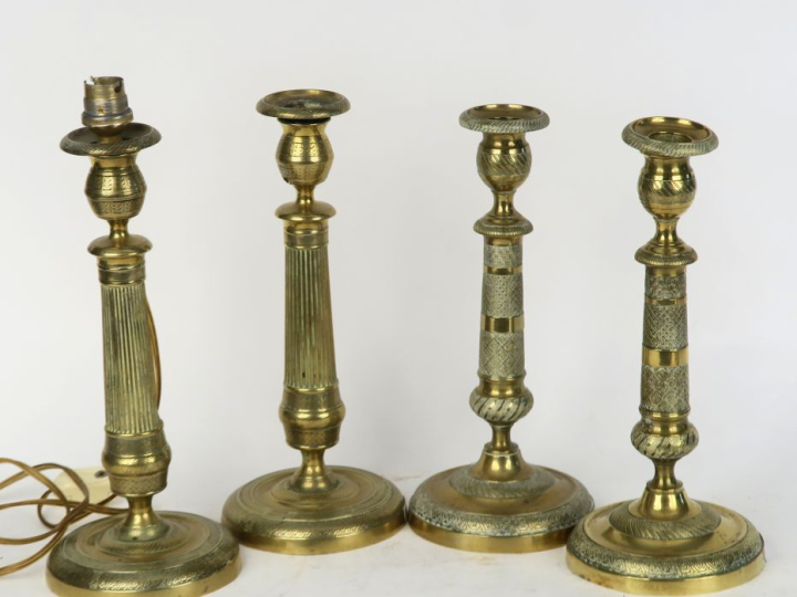 Deux différentes paires de bougeoirs de style Louis XVI en laiton. H. 