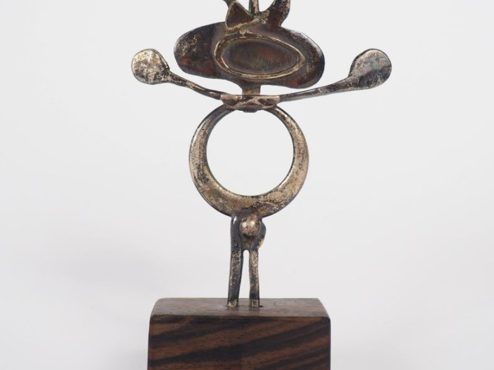 Figurine anthropomorphe en métal argenté, socle en bois. H. 8 cm.,