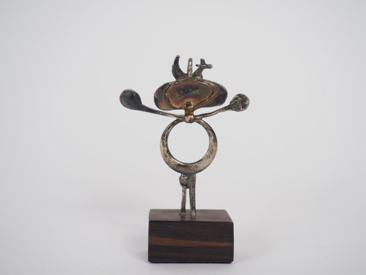 Figurine anthropomorphe en métal argenté, socle en bois. H. 8 cm.,