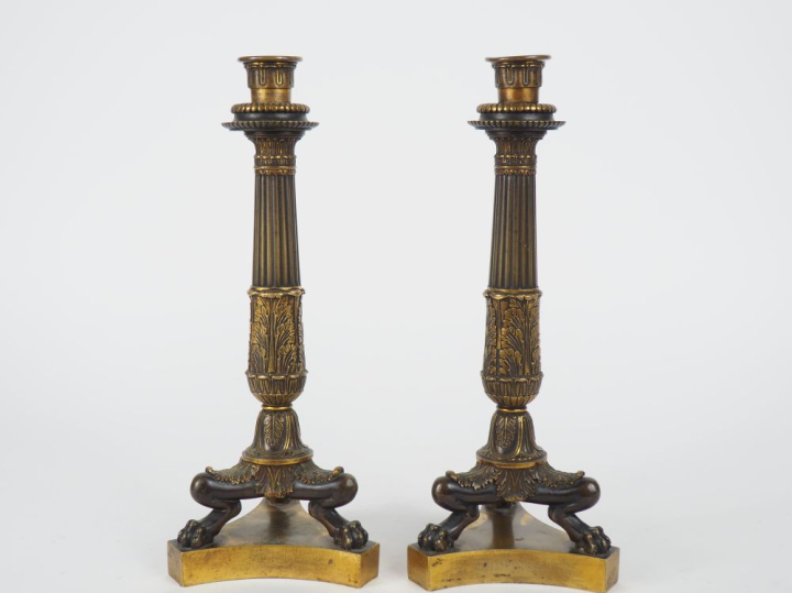 Paire de bougeoirs Restauration en bronze, pieds griffe à décor de god