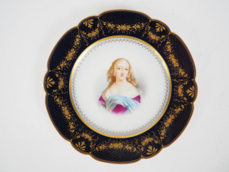 Vente aux enchères SEVRES.  Assiette en porcelaine à décor polychrome de jeune fille. Sig