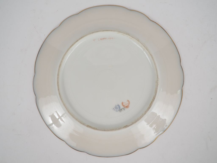 SEVRES.  Assiette en porcelaine à décor polychrome de jeune fille. Sig