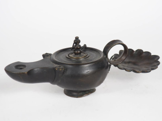 Vente aux enchères Lampe à huile de style antique en bronze à patine brune. Long. 27,5 cm