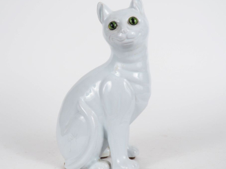 Vente aux enchères GALLE.  Chat en faience blanche. Signé. (égrenure et une patte acciden