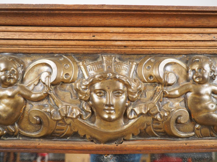 Glace de style Louis XIV, cadre en laiton repoussé à décor de personna