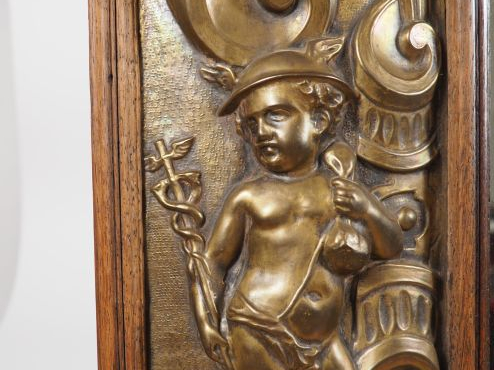 Glace de style Louis XIV, cadre en laiton repoussé à décor de personna