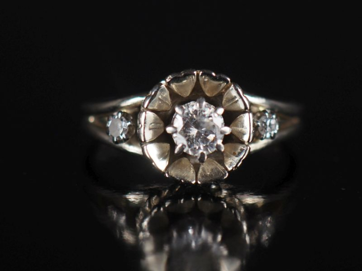 Bague marguerite en or blanc et trois diamants, le diamant central pes