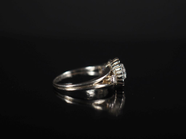 Bague marguerite en or blanc et trois diamants, le diamant central pes