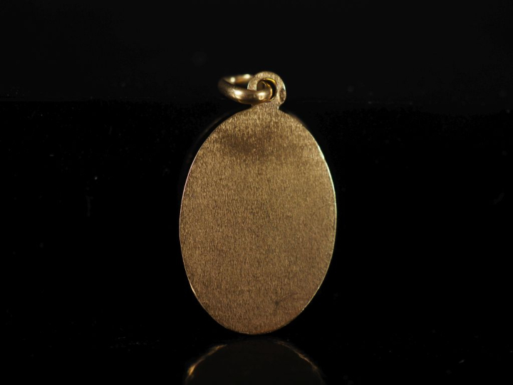 Médaille en or et émail, à décor de blason.  Poids tel : 2,90 g   