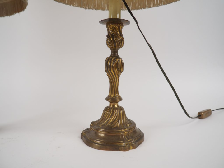 Deux différents bougeoirs de style Louis XV en métal, montés en lampe.