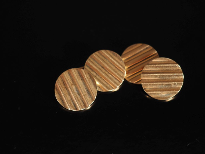 Paire de boutons de manchettes en or jaune 750, à décor ondulé.  Diam.