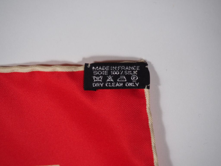 HERMES, Paris Carré de soie, à décor rayé blanc sur fond rouge.  Signé