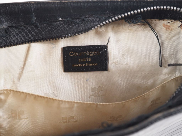 COURREGES, Paris Pochette en cuir noir.  Fermeture à zip, découvrant u