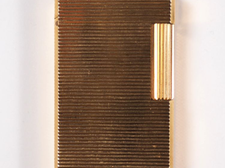 Briquet Dupont en métal doré, à décor de stries.  Signé.