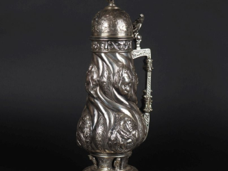 Vente aux enchères Grand pichet couvert en argent XIXème, décor en repoussé de chérubins,