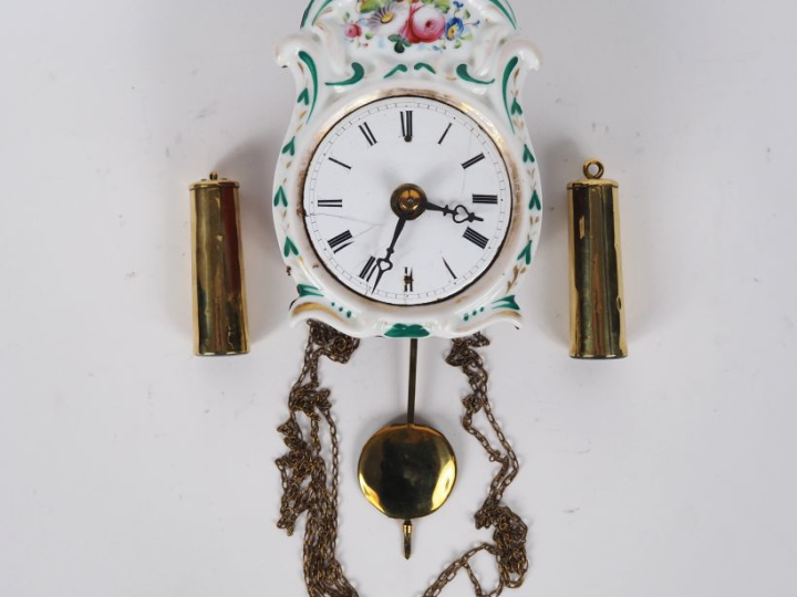 Pendulette murale en porcelaine à décor de fleurs polychrome, cadran é