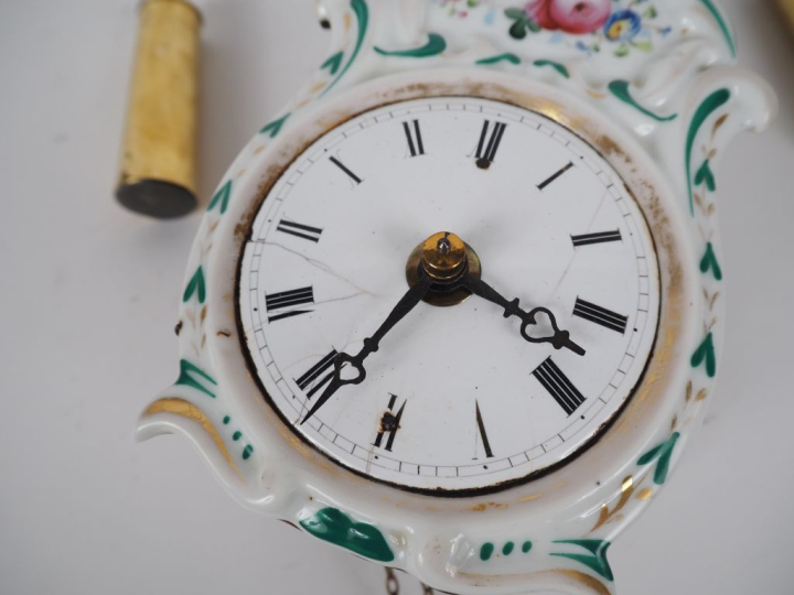 Pendulette murale en porcelaine à décor de fleurs polychrome, cadran é