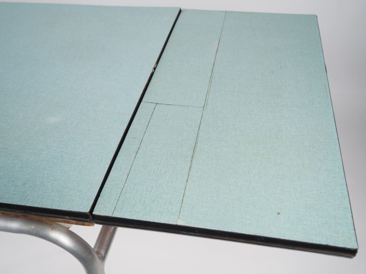 Table de cuisine en formica vert, piétement métallique, plateau à l'it
