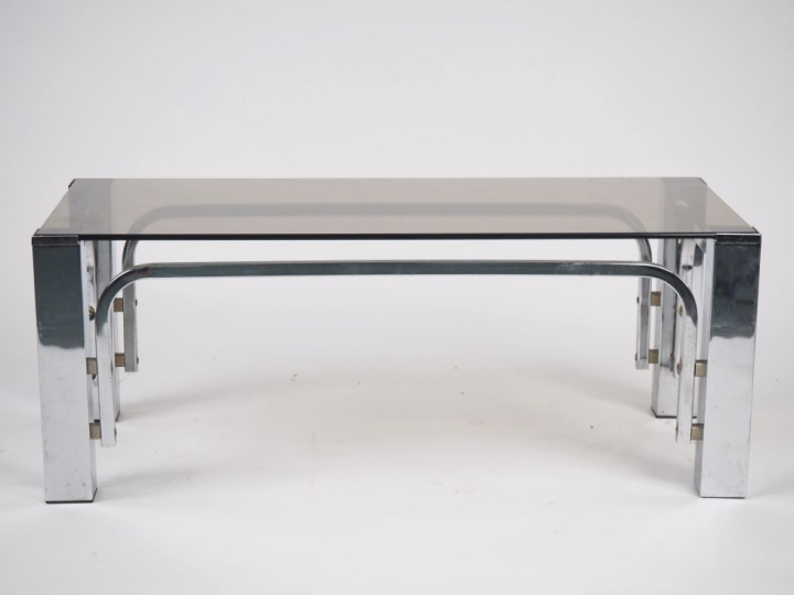 Table basse années 70 en métal chromé et verre fumé. Dim. 34,5 x 90 x 