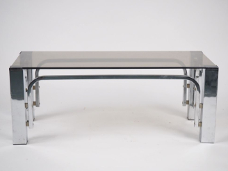 Vente aux enchères Table basse années 70 en métal chromé et verre fumé. Dim. 34,5 x 90 x 